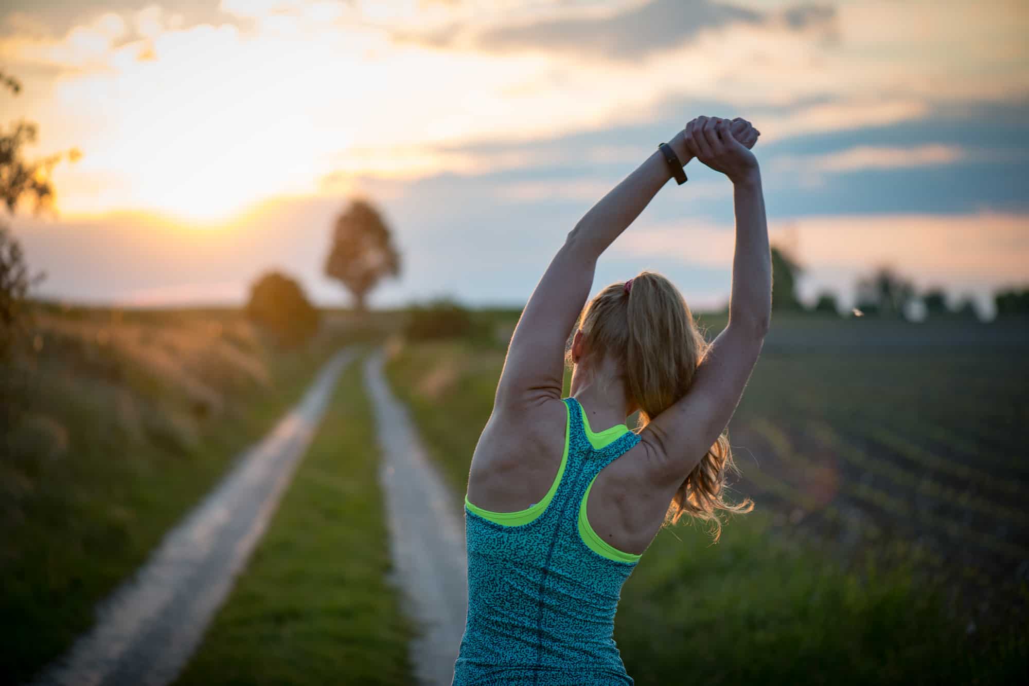 A woman is engaging in outdoor stretching exercises