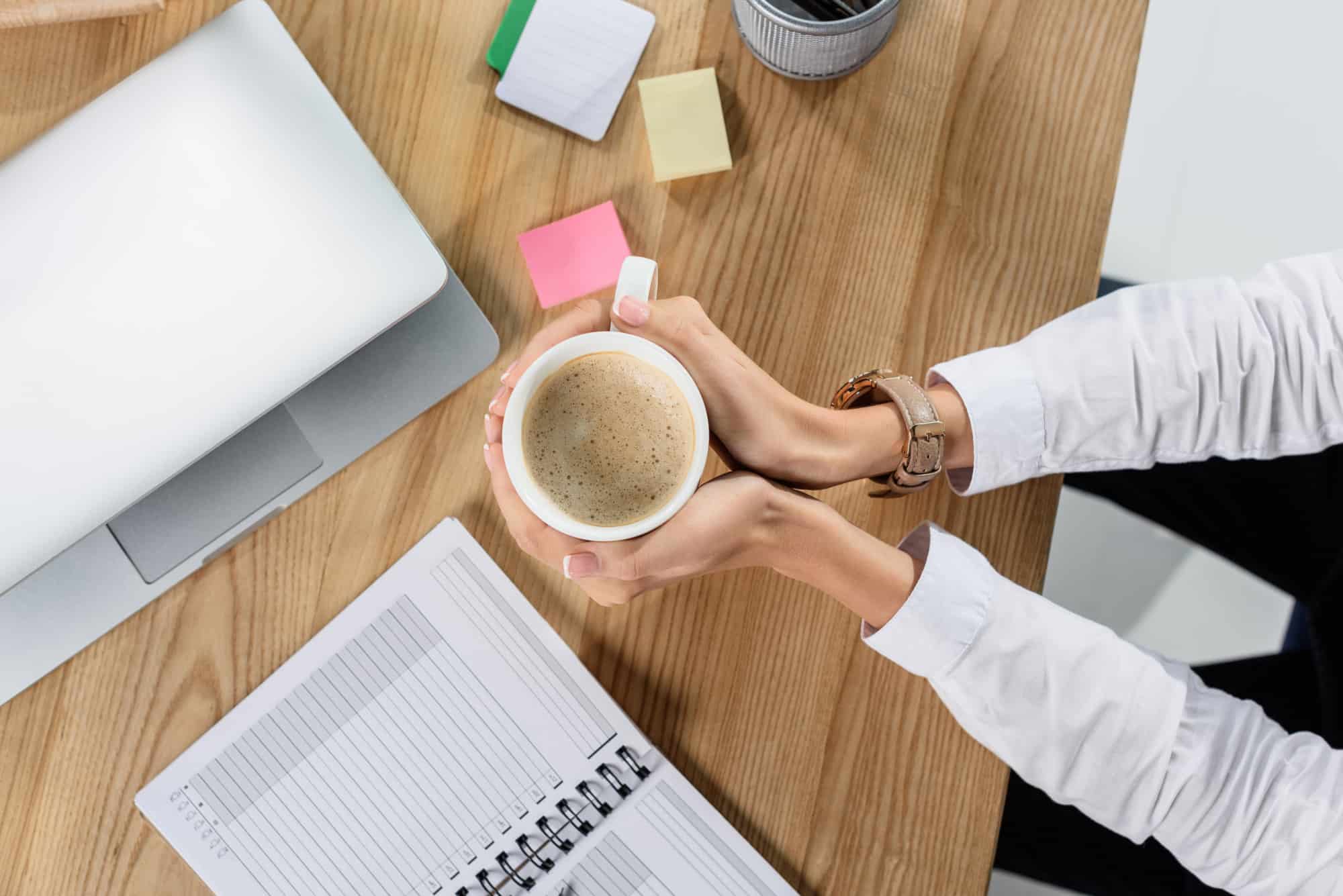 A woman is drinking coffee in the office