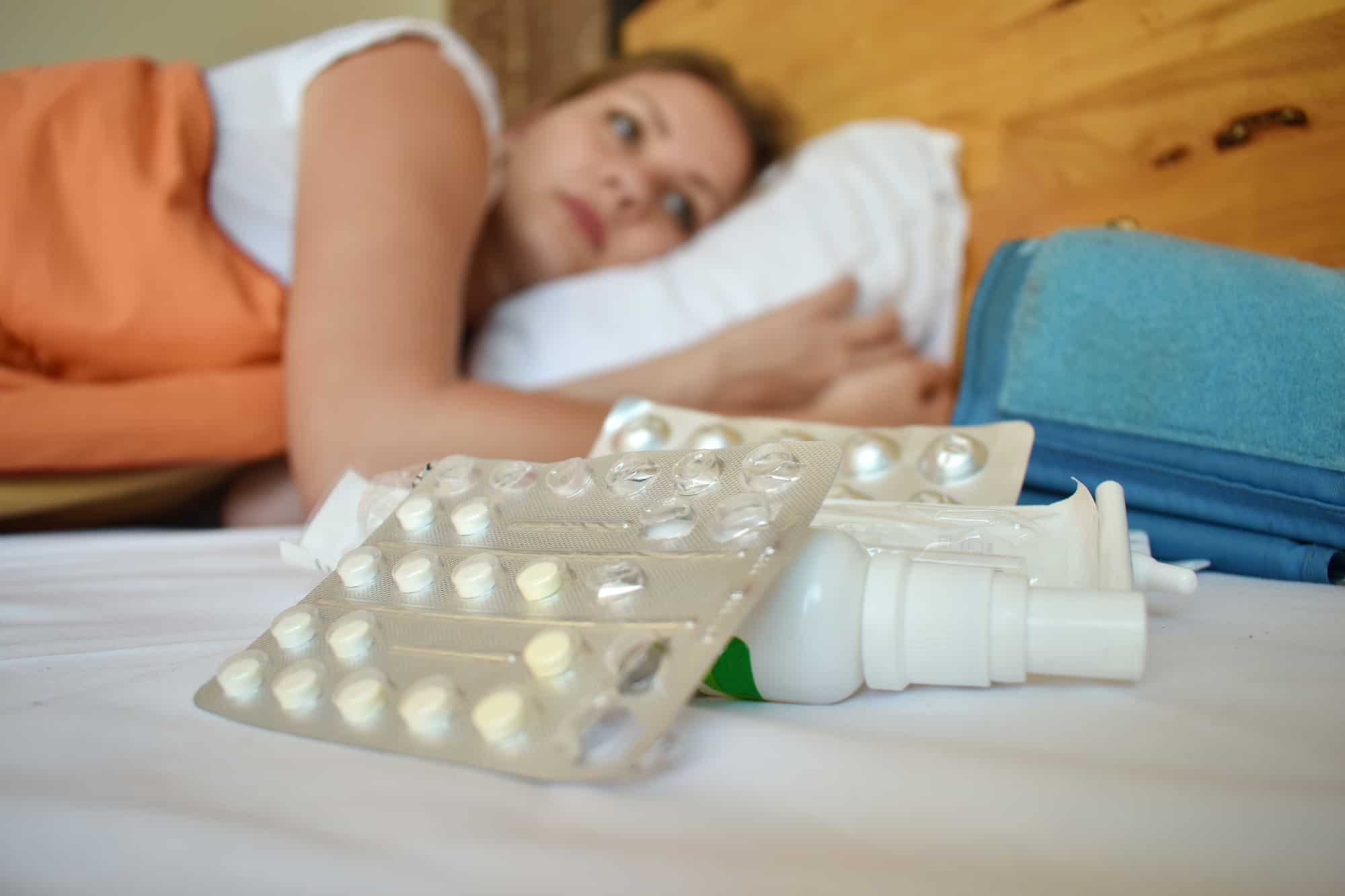 the woman is unwell and lying in bed with medication