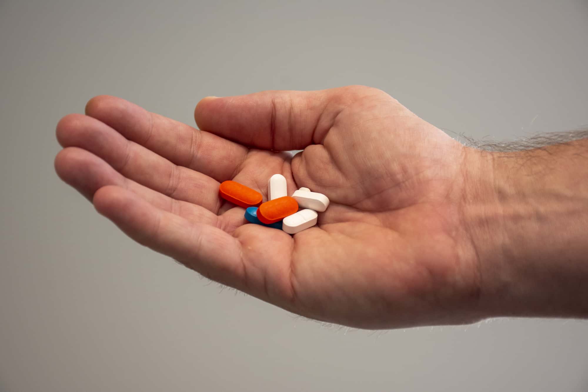 A man is holding pills for his medication