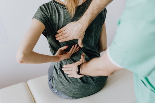 A woman receiving a chiropractic adjustment to maintain her health