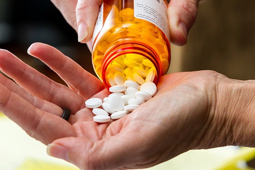 a hand handling opioids pills