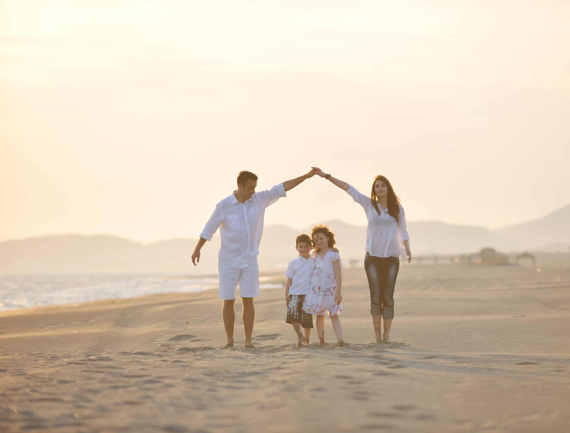 happy young family have fun on beach at sunset