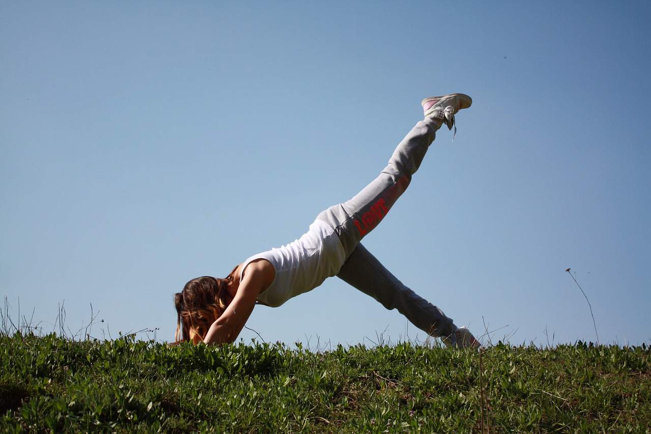 A woman is outdoors practicing proprioception exercises.