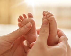 A mother is holding her baby's feet