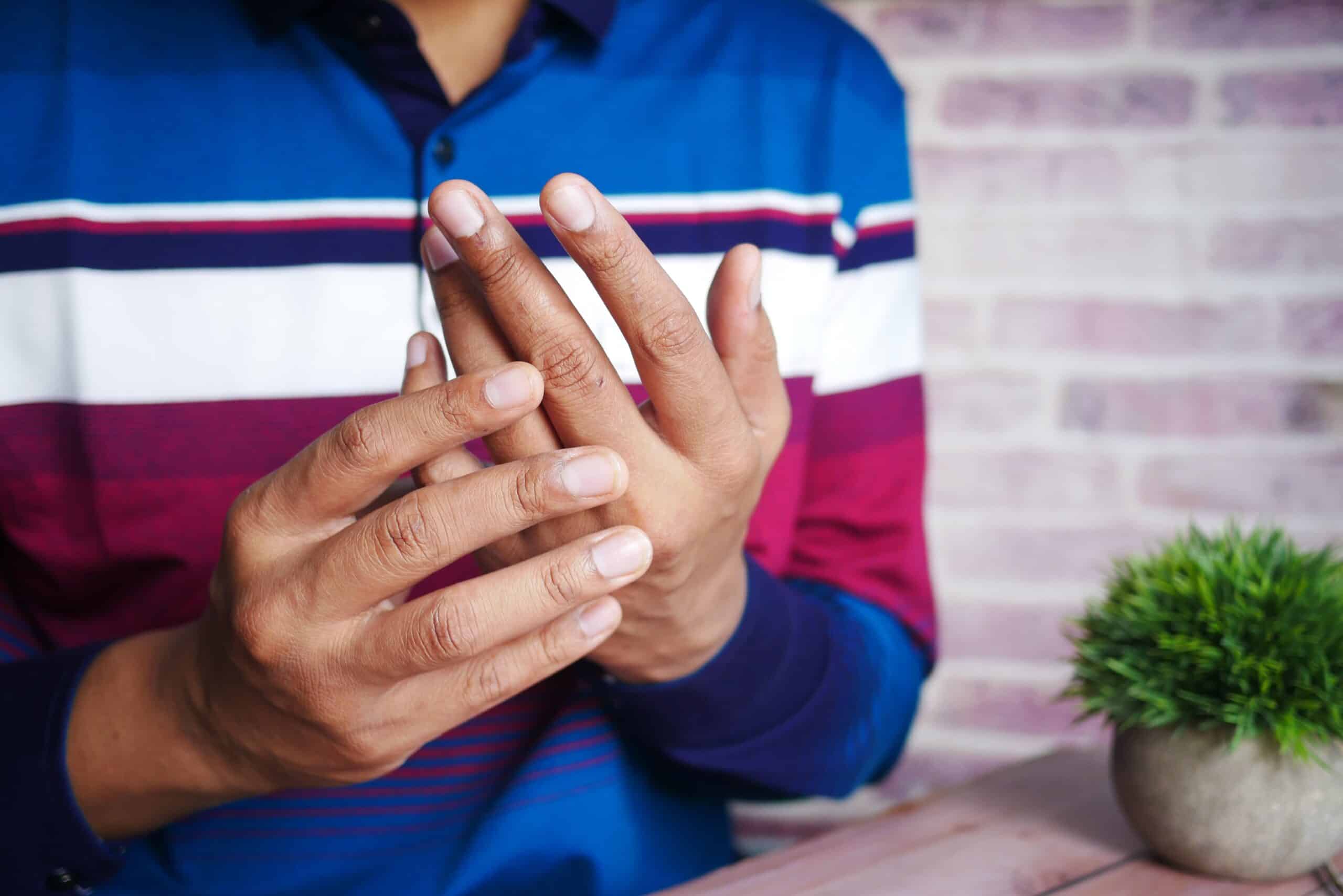 A man is experiencing pain in his hands